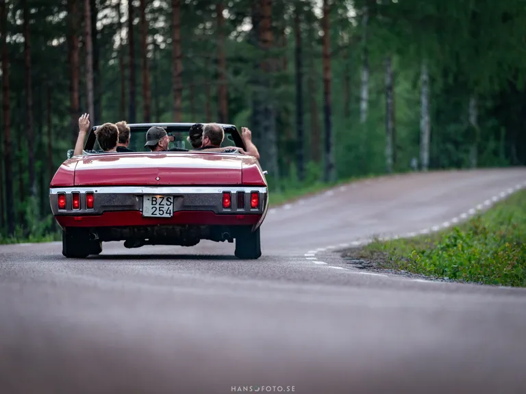 Kompisgäng som kör nercabbat i sin Chevrolet Impala från 1970.